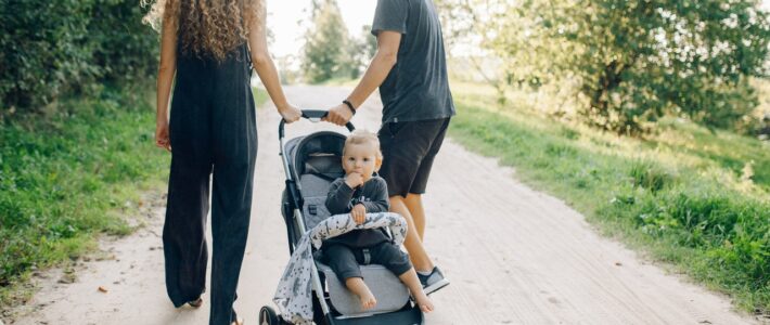 rodzina spacerująca z dzieckiem w wózku spacerowym